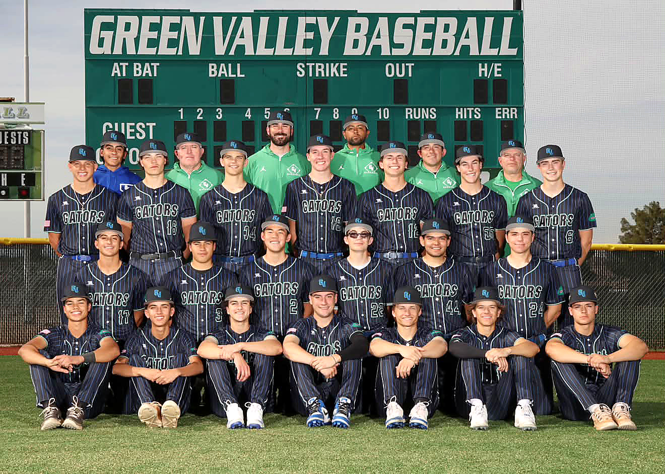 Green Valley Gators varsity team photograph in black pinstripe jerseys and caps, posed in three rows on the field in front of the Green Valley Baseball scoreboard